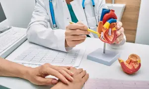 Lekarz omawia z pacjentem model serca i EKG, wyjaśniając ścieżkę rehabilitacyjną.