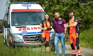 Trzech ratowników medycznych przy ambulansie. Zastanawiasz się, ile zarabia ratownik medyczny?