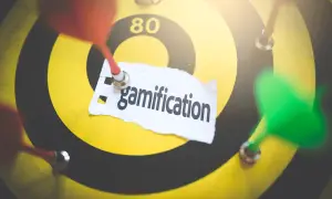 Rzutki na tarczy symbolizują cel, a napis "gamification" wskazuje na strategię grywalizacji w biznesie.
