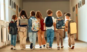 Grupa dzieci z plecakami idzie korytarzem szkolnym. Już planują, jak wykorzystają dni wolne od szkoły 2026.