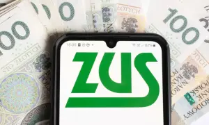 Telefon z logo ZUS na tle polskich banknotów 100 zł.