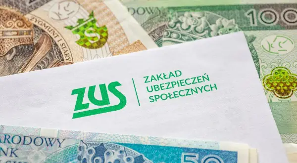 Koperta z logo ZUS na tle polskich banknotów.