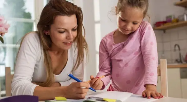 Mama i córka uczą się razem, analizując edukację domową wady i zalety.