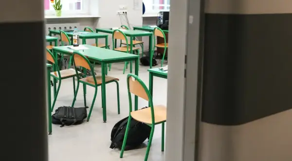 Puste ławki i krzesła w sali lekcyjnej, plecaki na podłodze. To znak, że zbliża się zakończenie roku szkolnego.