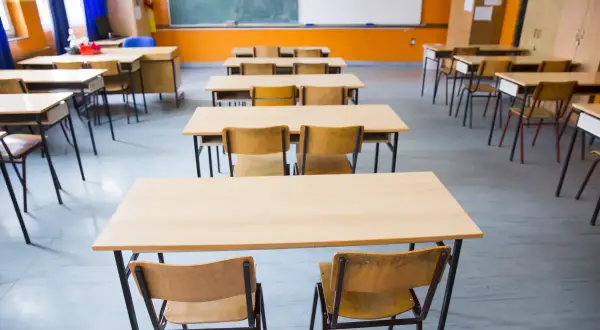 Puste ławki i krzesła w sali lekcyjnej. Obowiązek szkolny trwa do 18 roku życia.