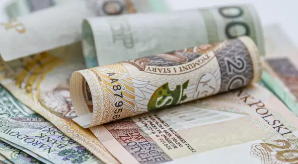 Zwijane banknoty 200 zł i 100 zł. Zastanawiasz się, ile wynosi świadczenie przedemerytalne na rękę?
