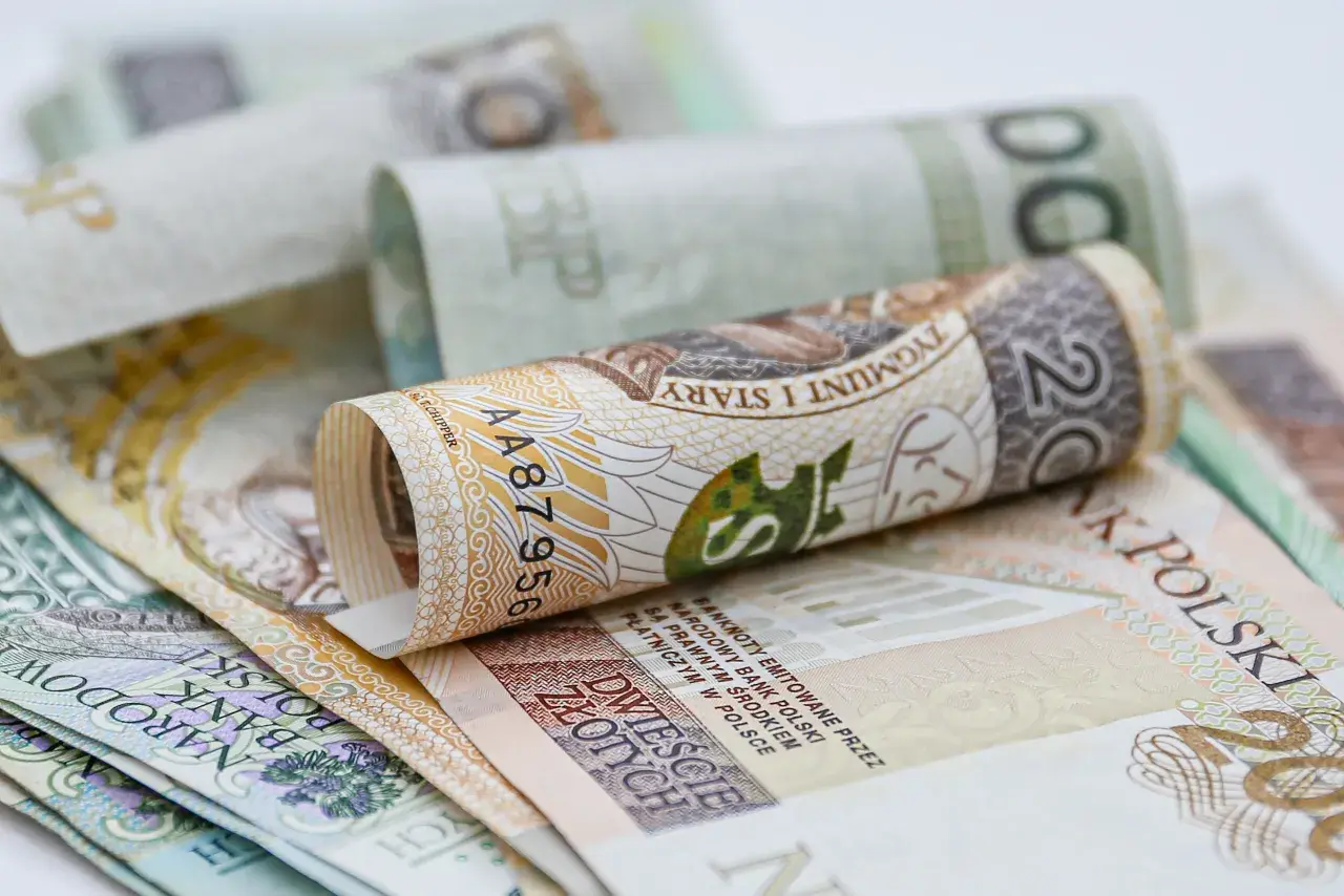 Zwijane banknoty 200 zł i 100 zł. Zastanawiasz się, ile wynosi świadczenie przedemerytalne na rękę?