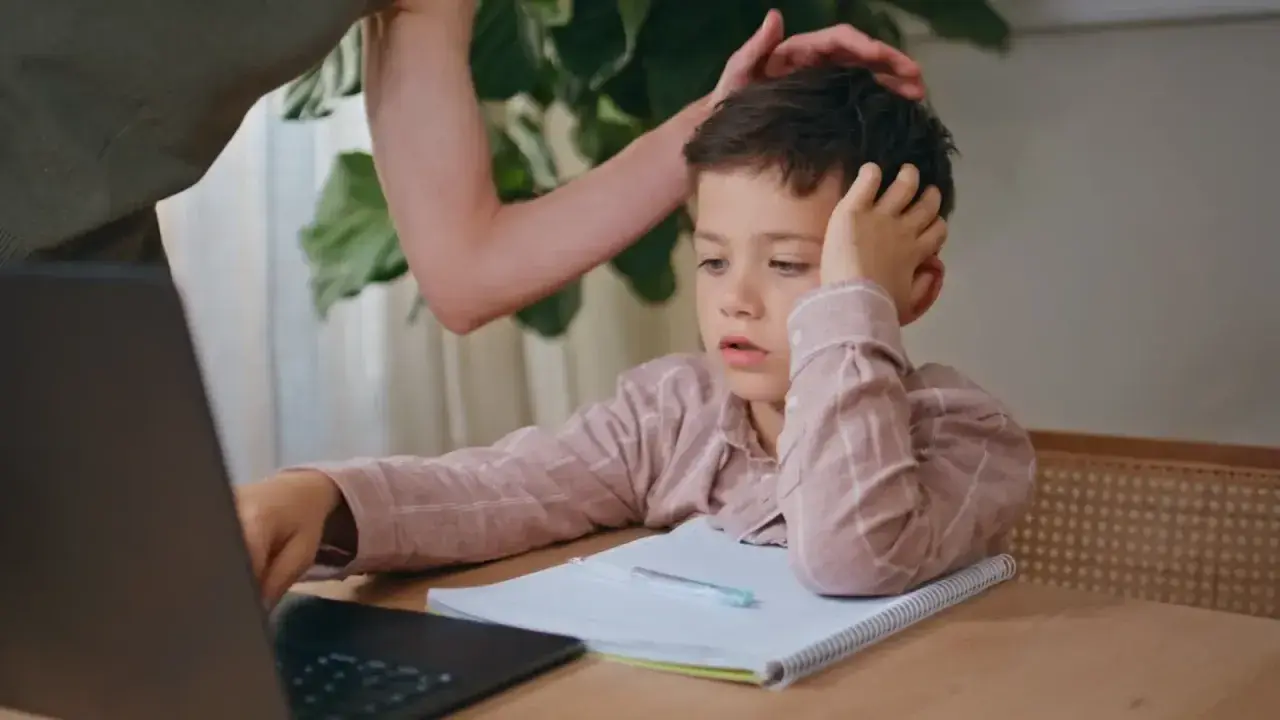 Chłopiec z rezygnacją opiera głowę na dłoni, wyraźnie widać, że dziecko nie chce się uczyć.