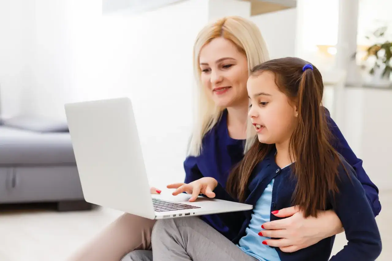 Mama próbuje zachęcić dziecko, które nie chce się uczyć, do pracy z laptopem.