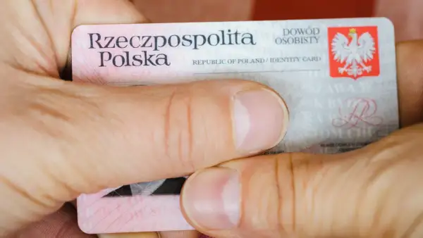 Dłonie trzymają polski dowód osobisty. Widoczna jest nazwa "Rzeczpospolita Polska" oraz godło. Widać fragmenty tekstu, w tym "seria i numer dowodu".