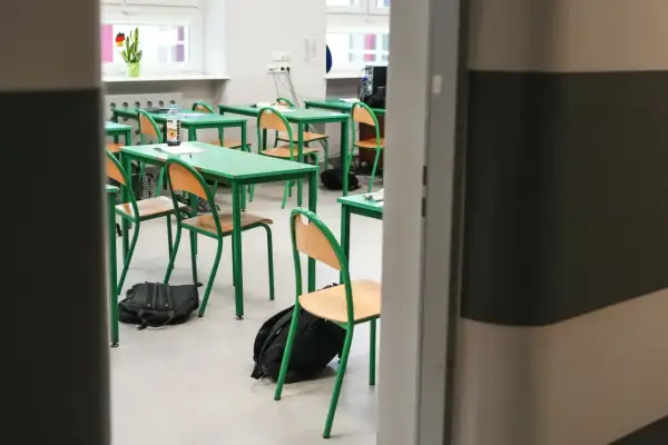 Puste ławki i krzesła w sali lekcyjnej, plecaki na podłodze. To znak, że zbliża się zakończenie roku szkolnego.